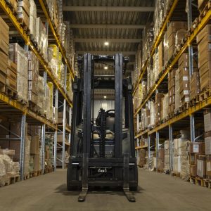Carrello elevatore in magazzino industriale durante attività logistica e movimentazione merci